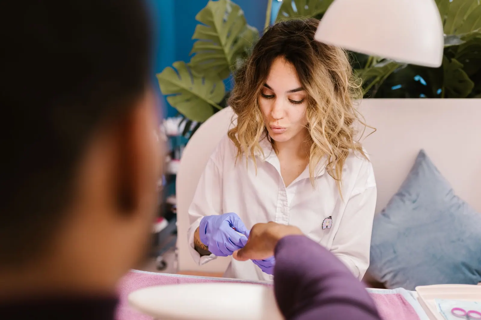 A woman providing a manicure service in a nail salon, showcasing self-care and professionalism. California Nail Salon Booking Laws: What Appointment Deposits Are Legal